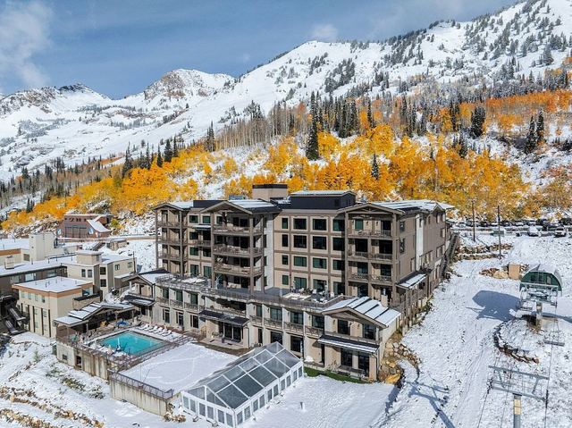 Snowpine Lodge with its heated outdoor pool, below fresh snow and golden aspens in Little Cottonwood Canyon